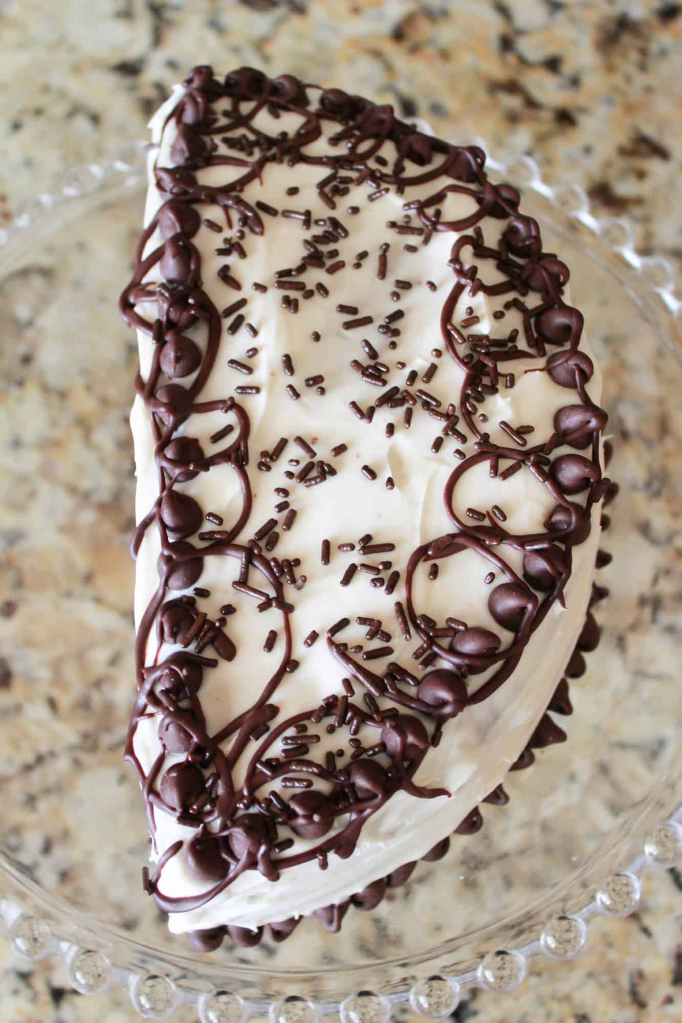 Half birthday cake on a glass plate.