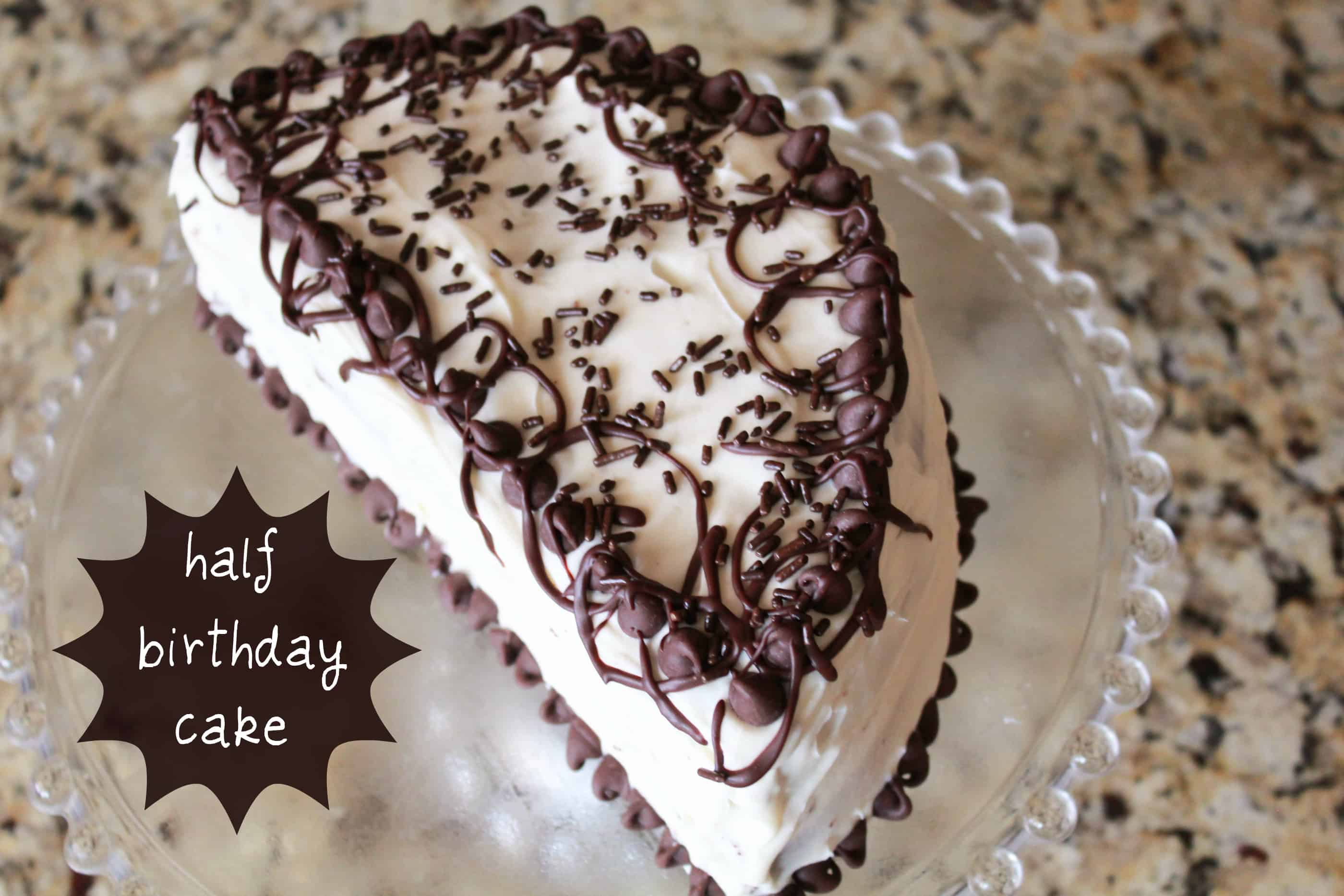 Half birthday cake on a glass plate.