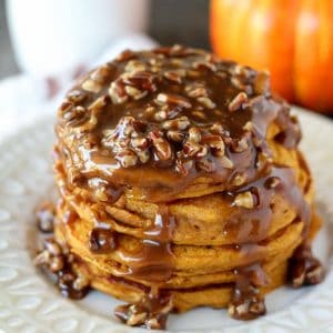 Stack of pumpkin pancakes topped with pecan syrup.