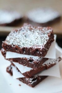 Stack of brownies topped with powdered sugar.