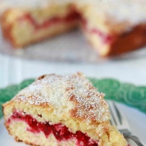 Slice of cranberry cake on a green and white plate.