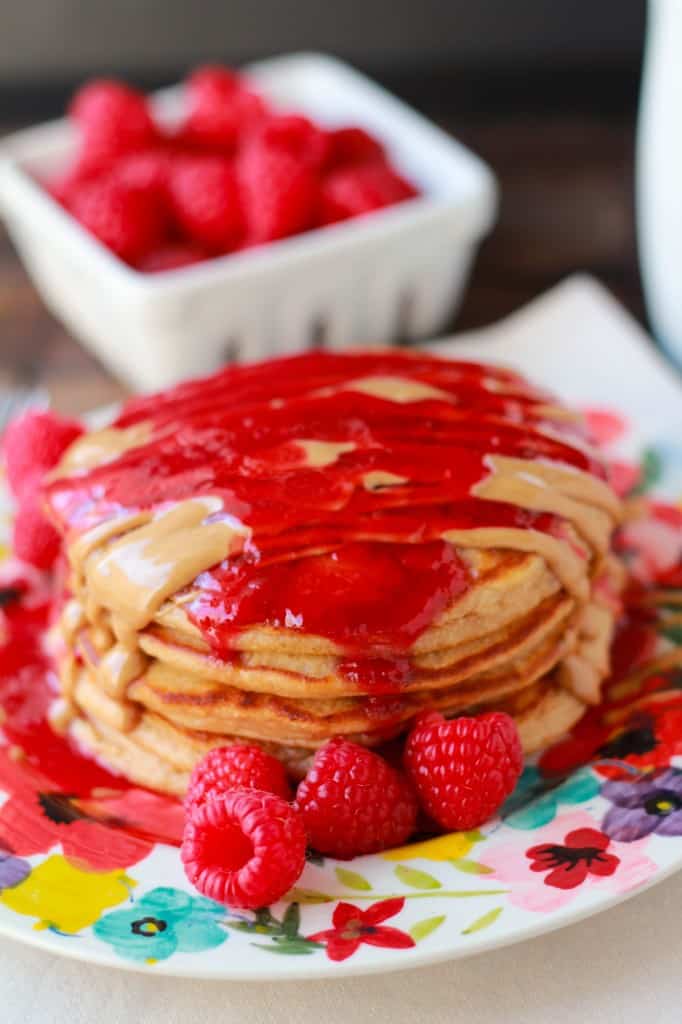 Stack of pancakes topped with melted peanut butter and jelly.