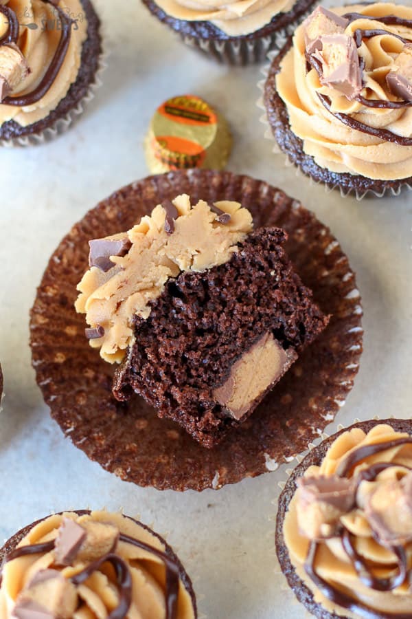 Half of a chocolate cupcakes with a peanut butter cup inside of it. 