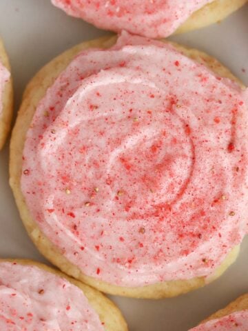 Closeup of sugar cookie topped with pink frosting.