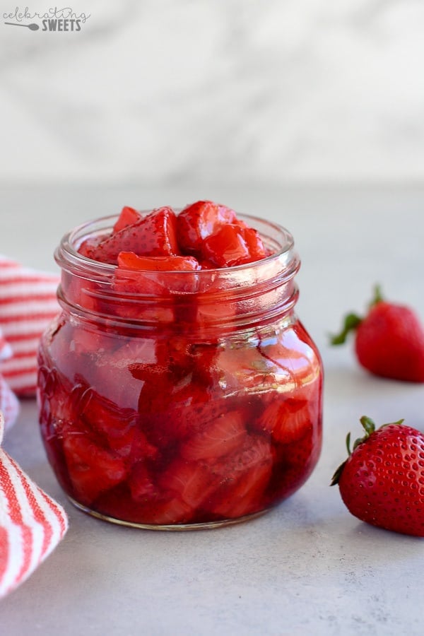 Roasted strawberries and strawberry sauce in a glass jar.