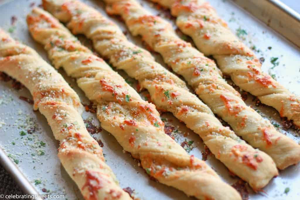 Twisted breadsticks on a baking sheet.