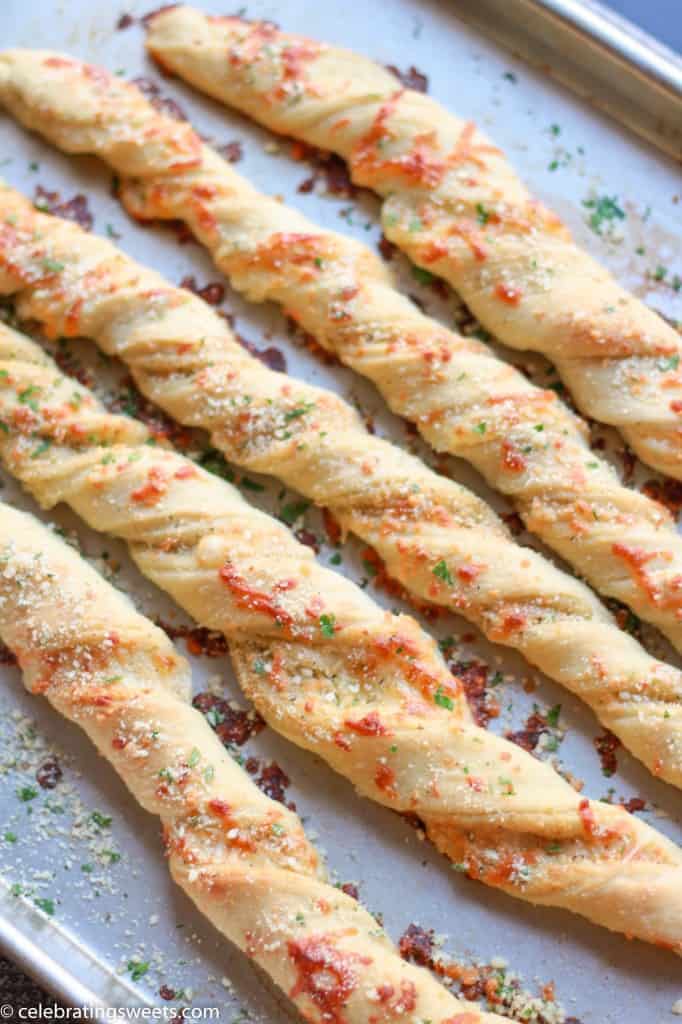 Twisted breadsticks on a baking sheet.