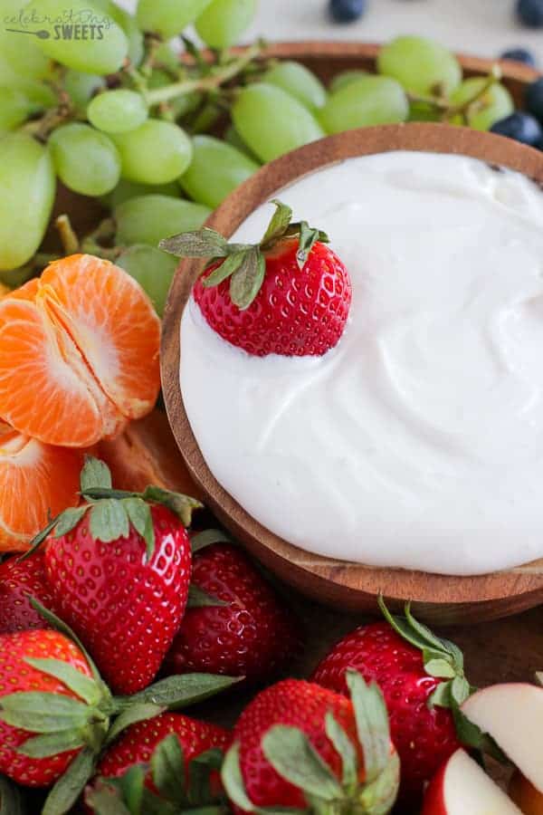 Bowl of dip with fruit around it.