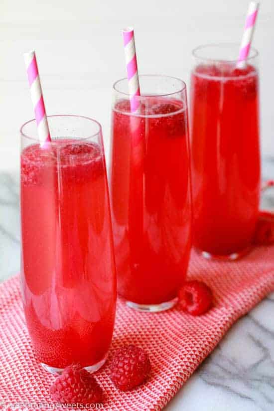 Three thin glasses filled with a pink beverage. 