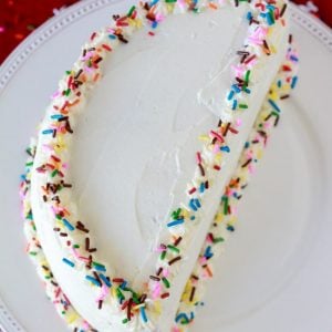 Half birthday cake with white frosting and colored sprinkles.
