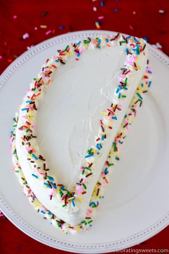 Half birthday cake with white frosting and colored sprinkles. 