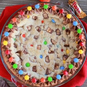 Cookie cake topped with M&M's candies and chocolate frosting.