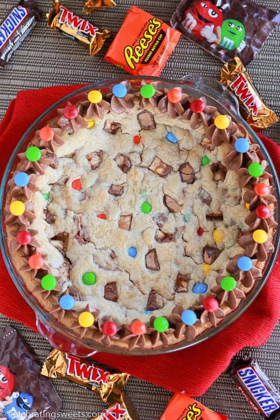 Cookie cake topped with M&M\'s candies and chocolate frosting.