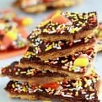 Stack of toffee bark topped with candy corn and halloween sprinkles.