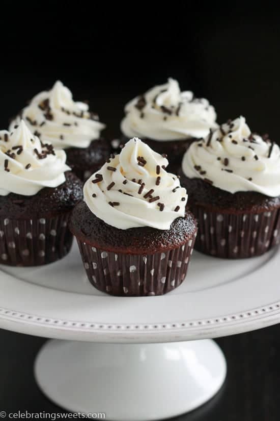 Five chocolate cupcakes topped with vanilla frosting. 