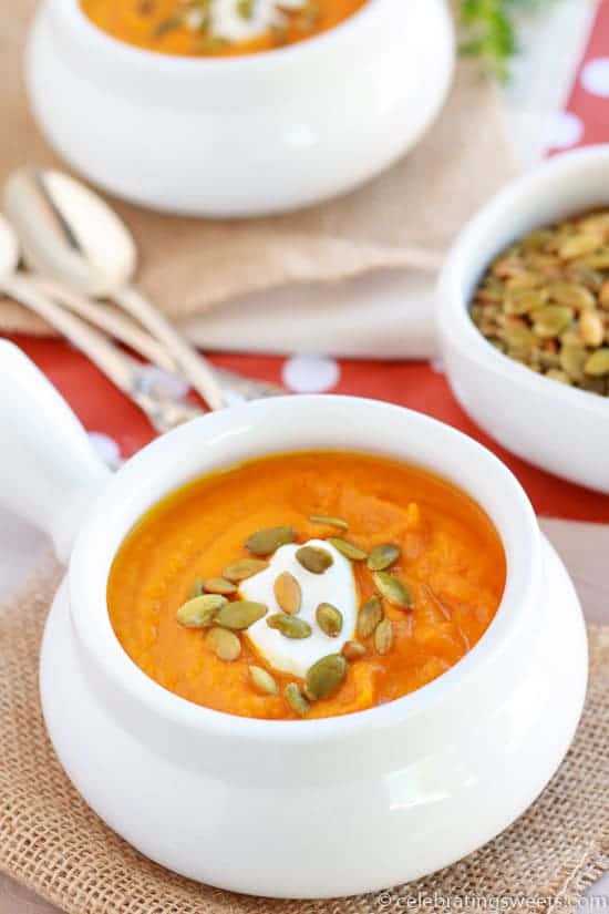 Butternut squash soup in a white bowl topped with pumpkin seeds.