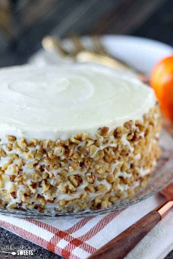 Round layer cake with white frosting and walnuts