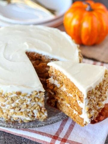 Close up of three layer carrot cake with white frosting.