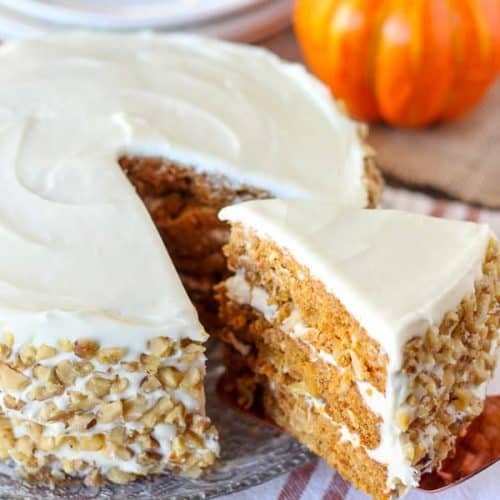 Close up of three layer carrot cake with white frosting.