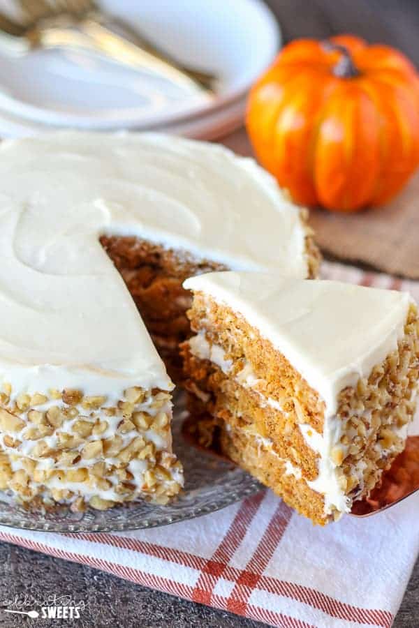 Close up of three layer carrot cake with white frosting. 