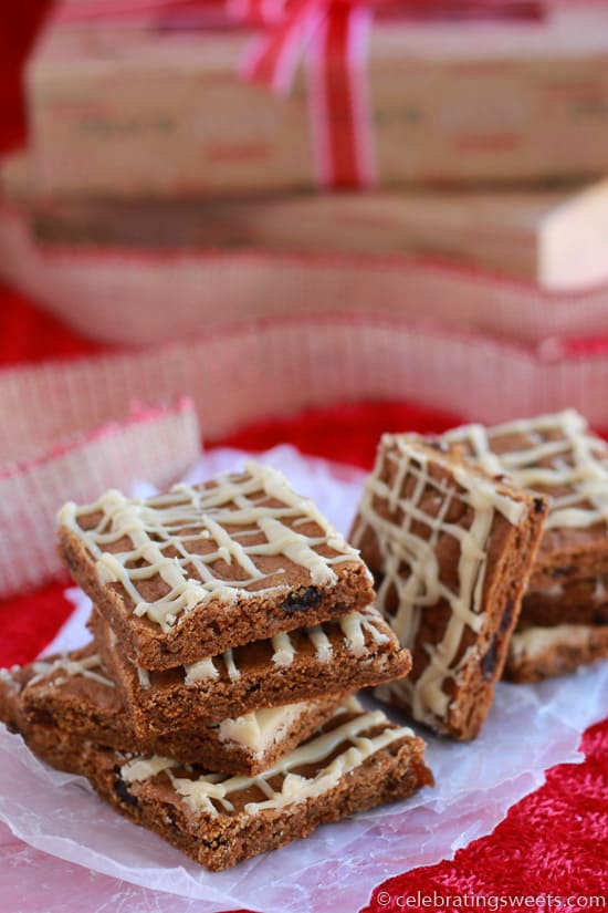 Gingerbread bars topped with icing on a piece of parchment paper. 