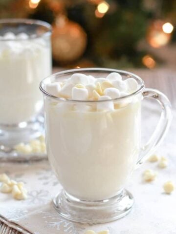 Glass mug filled with white hot chocolate.