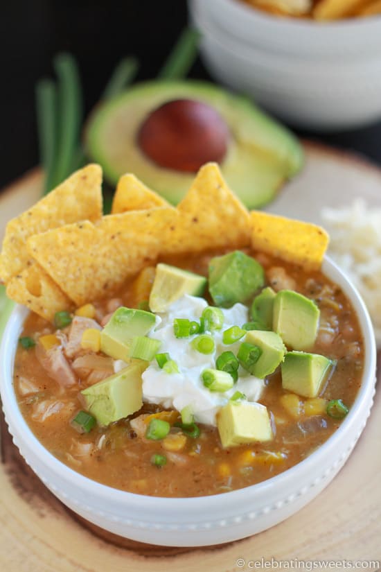 Bowl of chicken chili with tortilla chips, avocado, and sour cream.