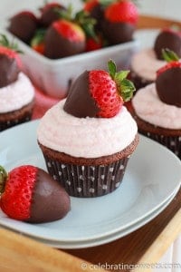 Chocolate cupcake topped with a chocolate dipped strawberry on a white plate. 