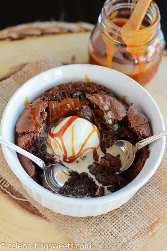 White bowl with a brownie inside, topped with vanilla ice cream and caramel sauce.
