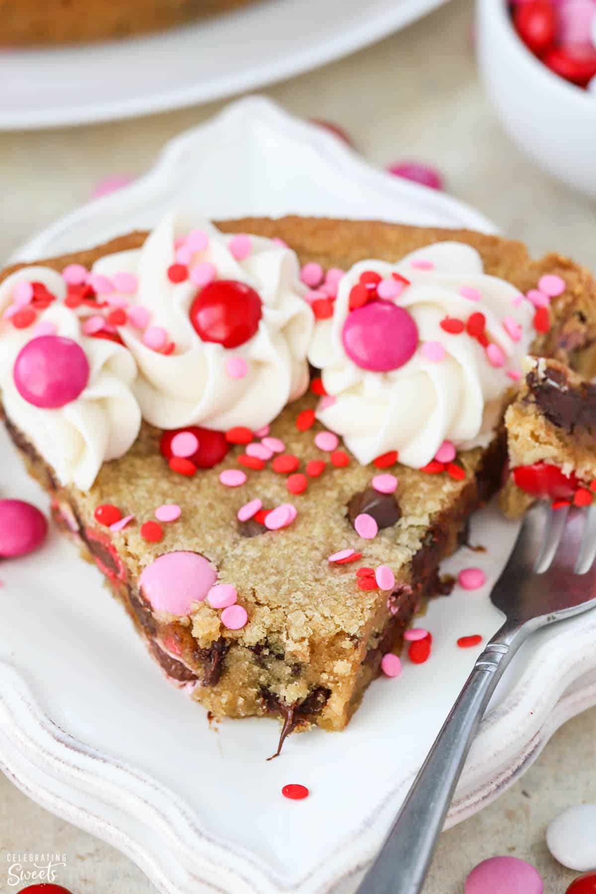Slice of cookie cake topped with pink and red M&M's