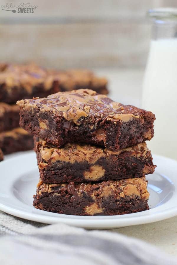 Stack of three peanut brownies on a plate.