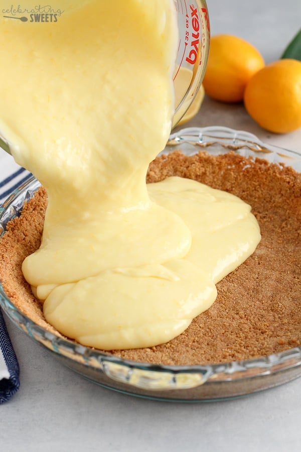 Lemon filling being poured into a graham cracker crust.