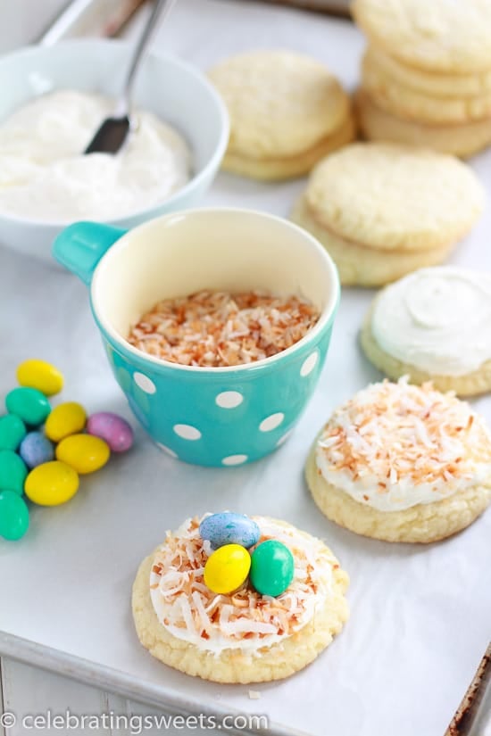 Sugar cookies, coconut, egg shaped candies on a white board.