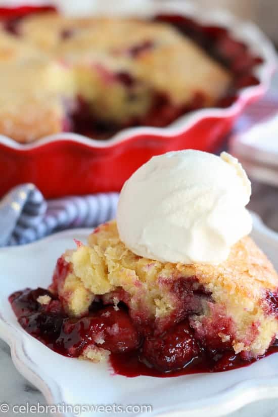 Berries topped with cake and a scoop of ice cream on a white plate.