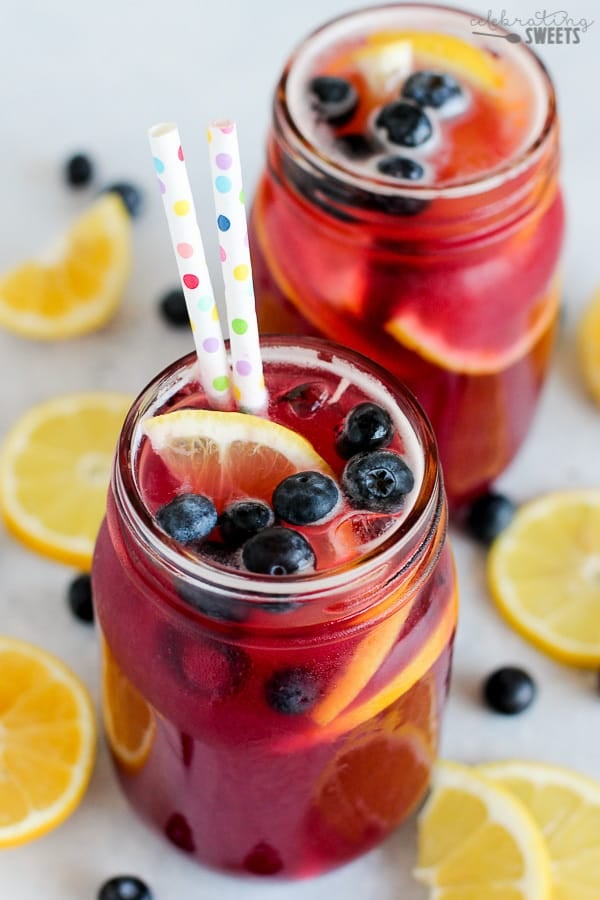 Glass jar filled with lemons, blueberries and lemonade