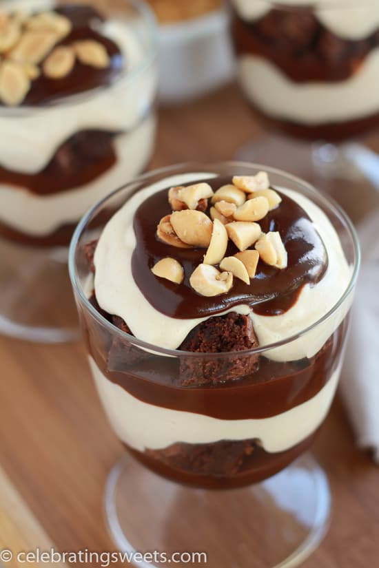 Glass with layers of brownies, whipped cream, and fudge sauce. 