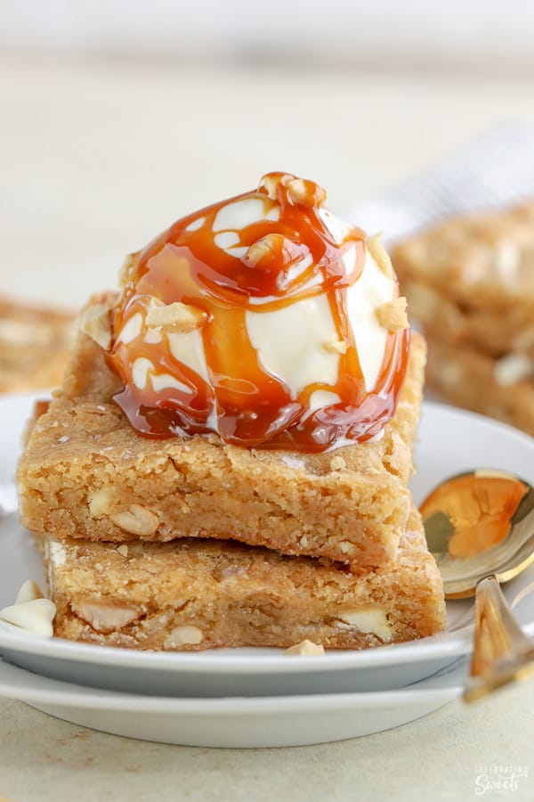 Stack of blondies with a scoop of vanilla ice cream and caramel sauce. 