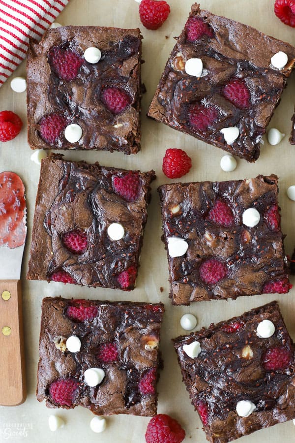 Raspberry brownies on a piece of brown parchment paper. 