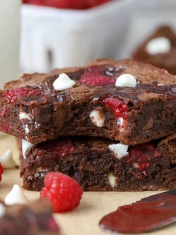 A close up of two brownies on parchment paper.