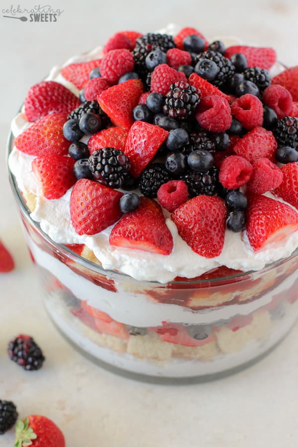 Trifle dish filled with cake, berries, and whipped cream.