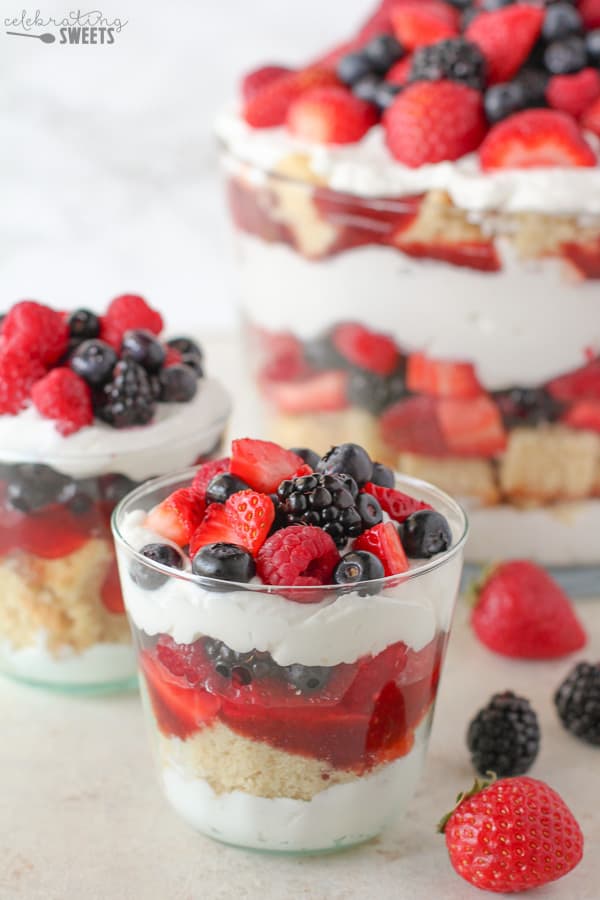 Trifle dish filled with cake, berries, and whipped cream.