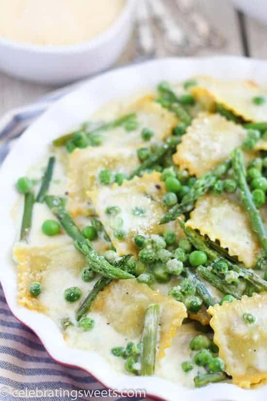 Ravioli with peas and asparagus in a baking dish.