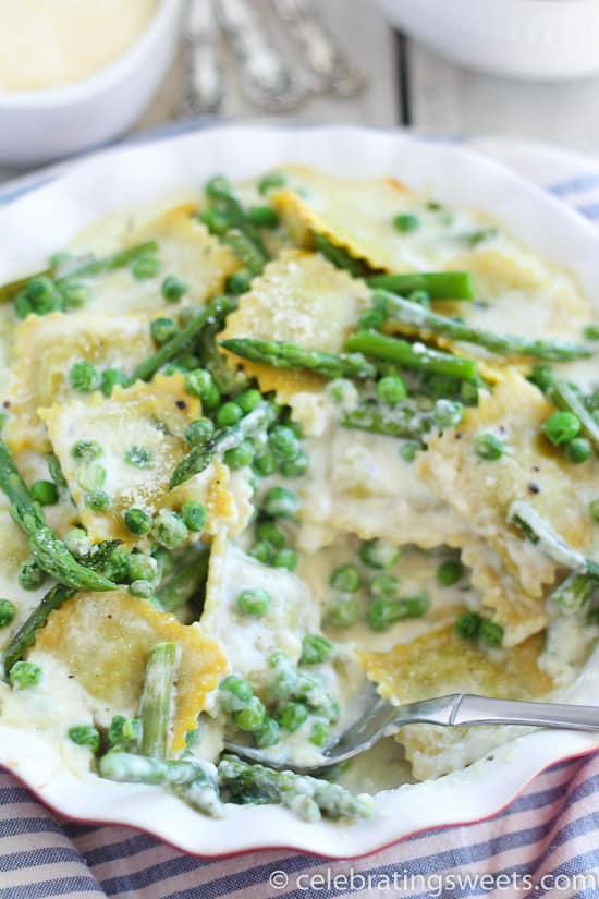 Ravioli with peas and asparagus in a baking dish.