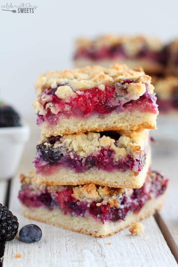 Three berry crumble bars stacked on top of eachother. 