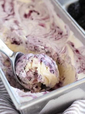 Blackberry vanilla ice cream in a metal loaf pan.