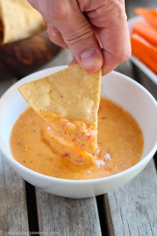 Tortilla chip in a bowl of cheese dip.