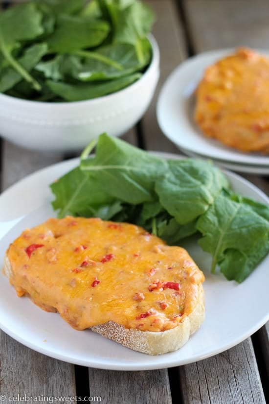 Toast with melted cheese and a salad on a white plate.