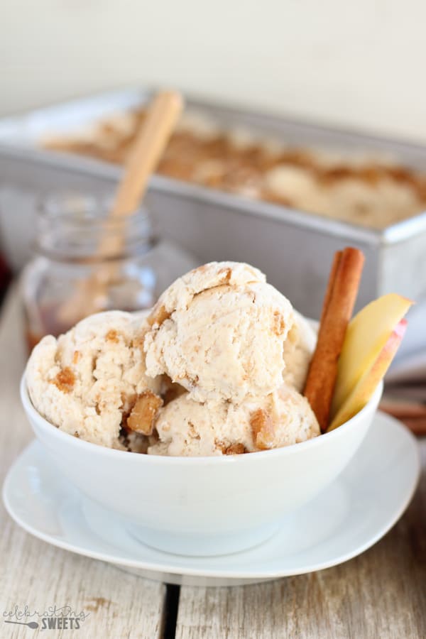 Scoops of apple pie ice cream in a white bowl garnished with a cinnamon stick.