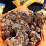 Chocolate bark in a bowl with an orange napkin.