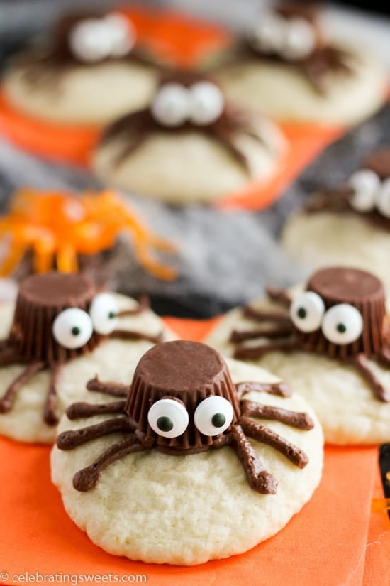 Sugar cookies decorated to look like a spider on an orange napkin.